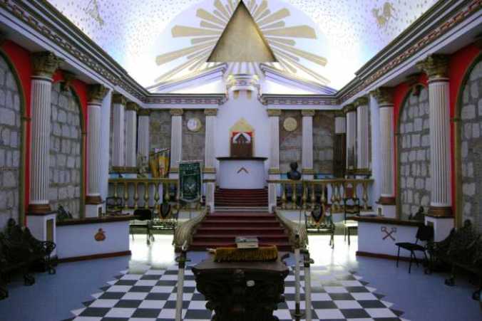 A free-masonic lodge. Along with the checkerboard floor we have the familiar staircase, pillars and pyramid.